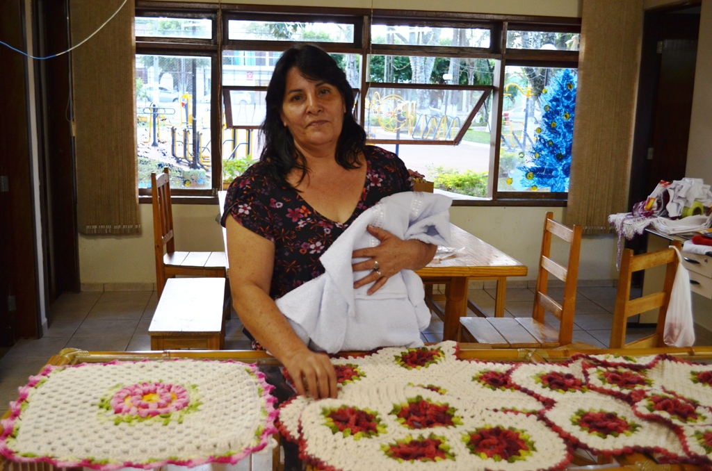 Dona Ines mostrando alguns dos trabalhos em crochê.